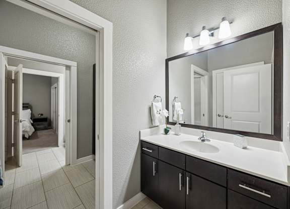 A bathroom with a white sink and a mirror above it.