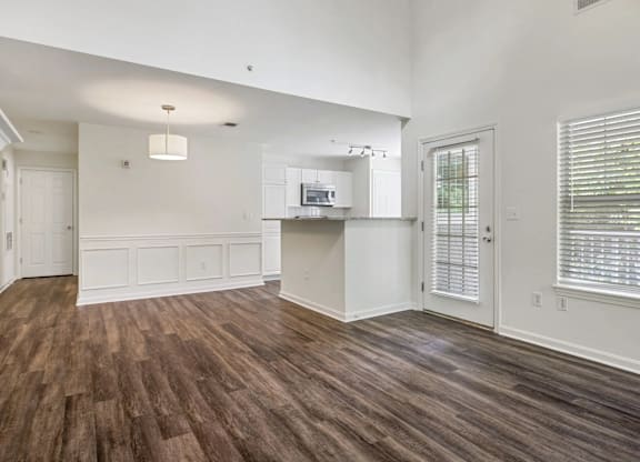 Open floorplan layout with wood style flooring and  wainscot wall