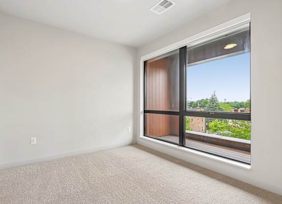 A room with a large window and a view of a cityscape.