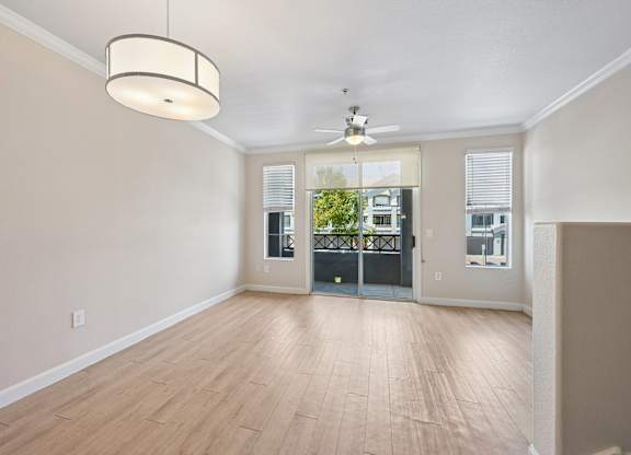 A room with a wooden floor and a ceiling fan.