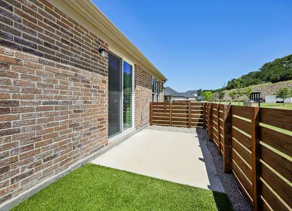 A modern house with a brick wall and a wooden fence.