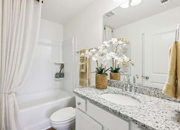 A white bathroom with a toilet, sink, and bathtub.