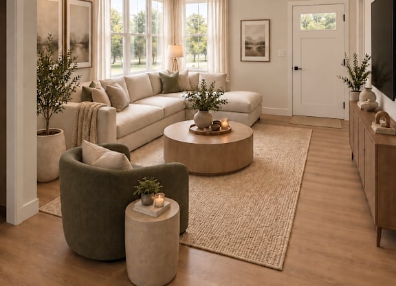 A modern living room with a large couch, a coffee table, and a flat-screen TV.
