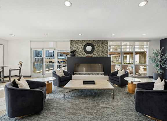 A modern living room with a fireplace and black furniture.