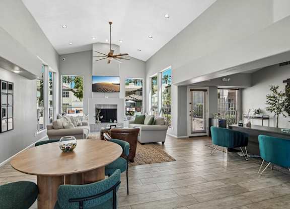 A modern living room with a wooden table and blue chairs.