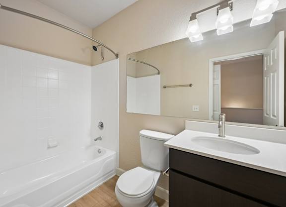 A white bathroom with a toilet, sink, and bathtub.