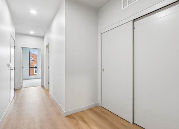 A long hallway with a white door on the right.