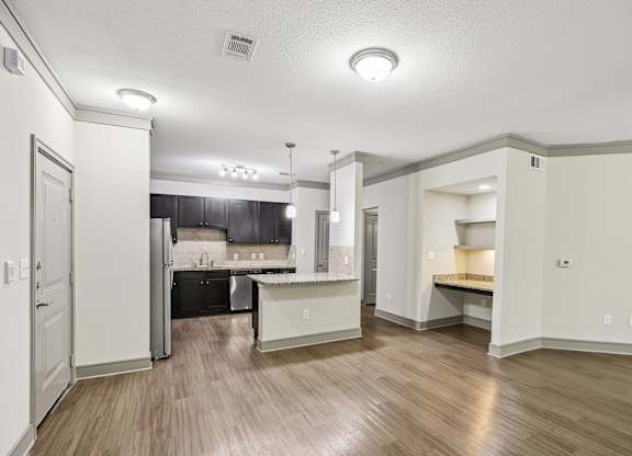 A kitchen with a refrigerator, sink, and countertop.