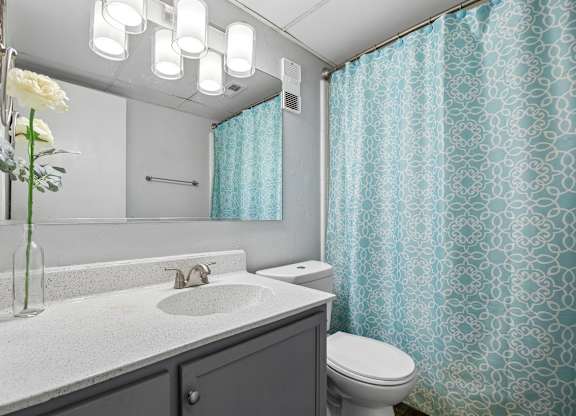 A bathroom with a white sink and a white toilet.