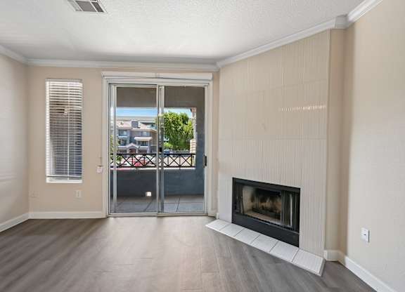 A living room with a fireplace and sliding glass doors.