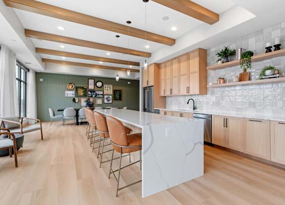 a large kitchen with a large white island and wood floors