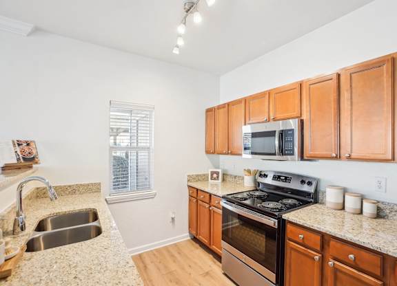 A kitchen with wooden cabinets and a granite countertop.