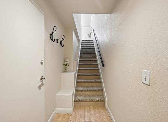A staircase with a light switch on the wall.