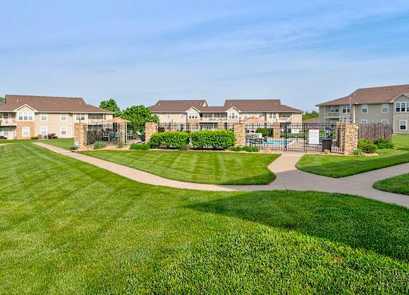 A large grassy area in front of apartment buildings.