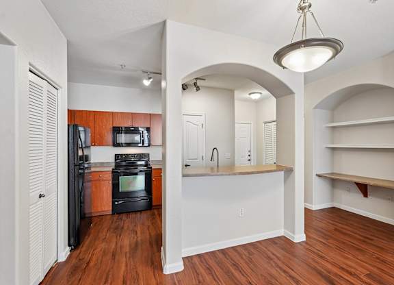 A kitchen with a refrigerator, microwave, and oven.