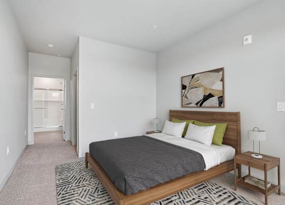 A bedroom with a large bed and a painting on the wall.