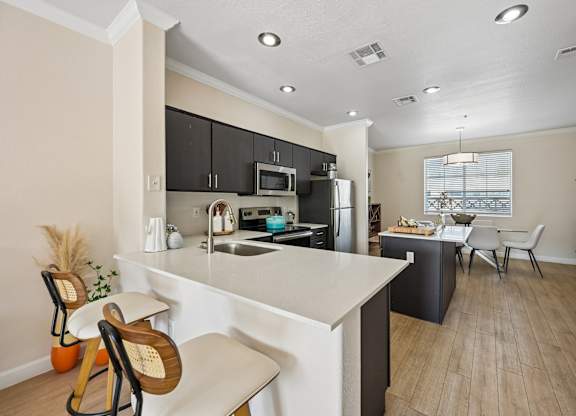 A kitchen with a white countertop and black cabinets.