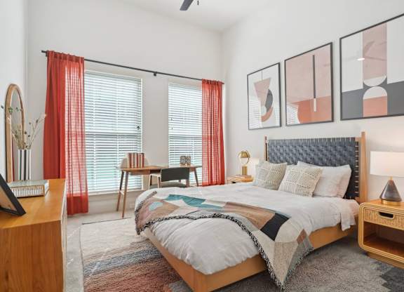 A bedroom with a large bed and a wooden nightstand.