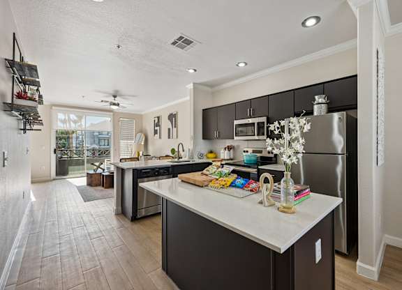 A kitchen with a refrigerator, microwave, and oven.