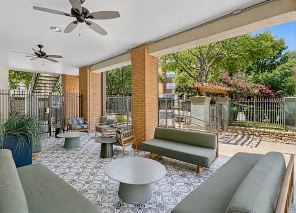 A patio with a table and chairs and a ceiling fan.