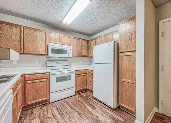 A kitchen with wooden cabinets and white appliances.