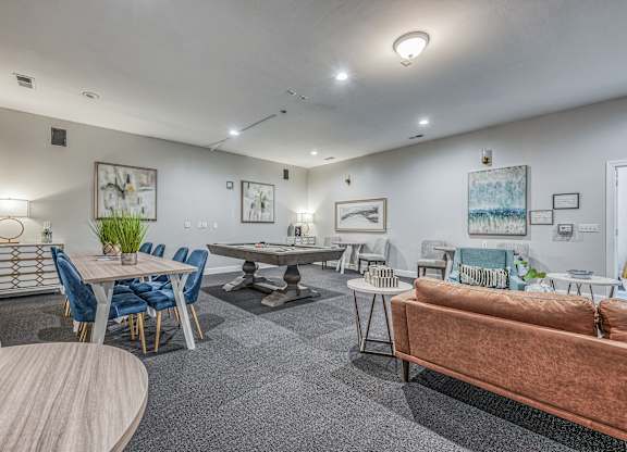 A living room with a brown couch, a dining table with chairs, and a pool table.