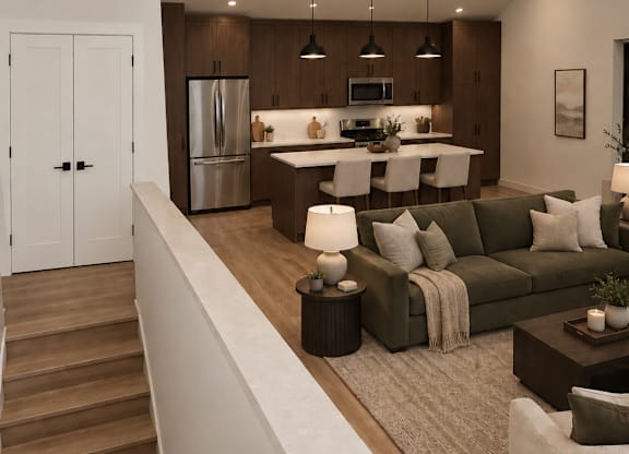 A modern kitchen with a refrigerator, microwave, and oven, with a dining area featuring a couch, chairs, and a coffee table.