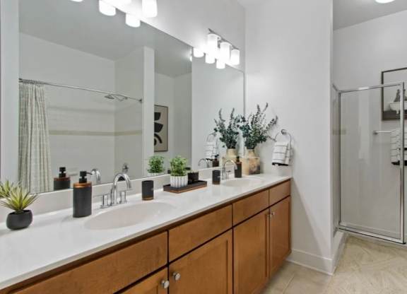 A bathroom with a double sink vanity and a walk-in shower.