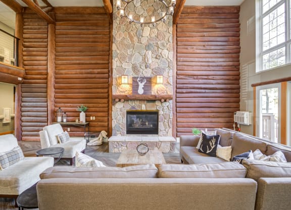 a large living room with a stone fireplace and couches at Birchwood Apartment Homes in Maple Grove, MN