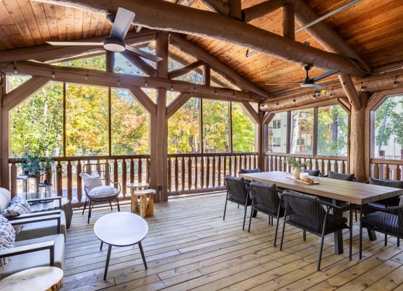 a screened in porch with a dining table and chairs at Birchwood Apartment Homes in Maple Grove, MN