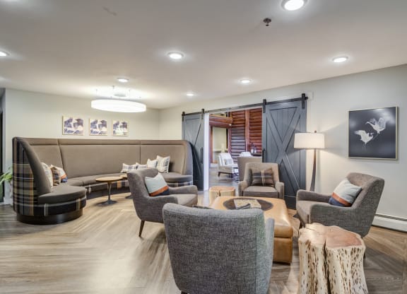 a living room with couches chairs and a table at Birchwood Apartment Homes in Maple Grove, MN