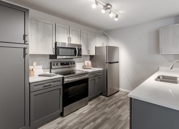our spacious kitchen is equipped with stainless steel appliances and white quartz counter tops