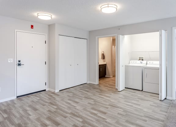 a white kitchen and laundry room with a wood floor and white doors