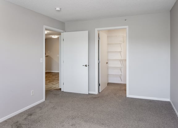 an empty bedroom with a closet and an open door to the bathroom
