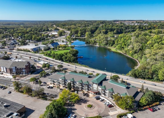 an aerial view of a city with a lake and trees