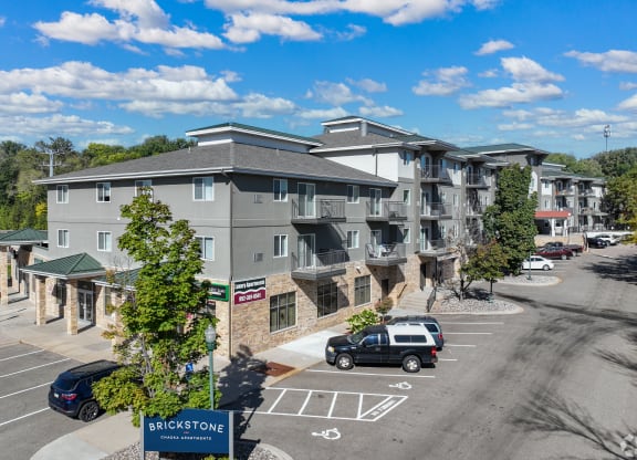 a large apartment building with cars parked in a parking lot