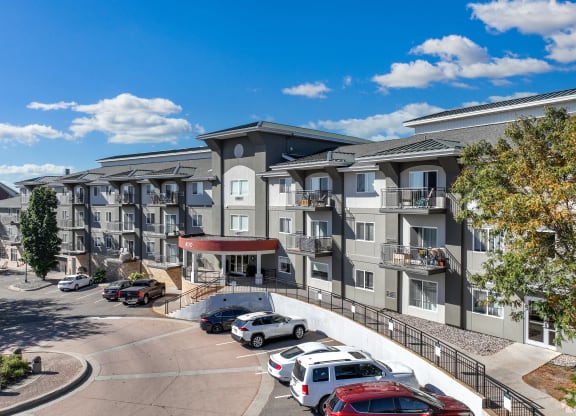 an apartment building with cars parked in a parking lot