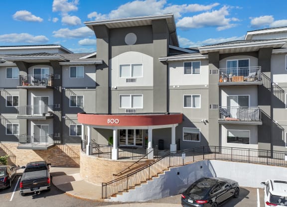 a large apartment building with cars parked in front of it