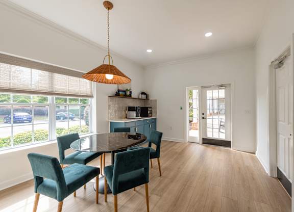A dining room with a table and chairs.