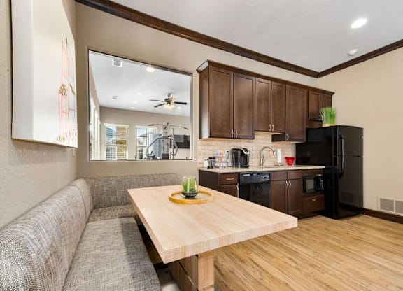 A modern kitchen with a wooden table and a couch.