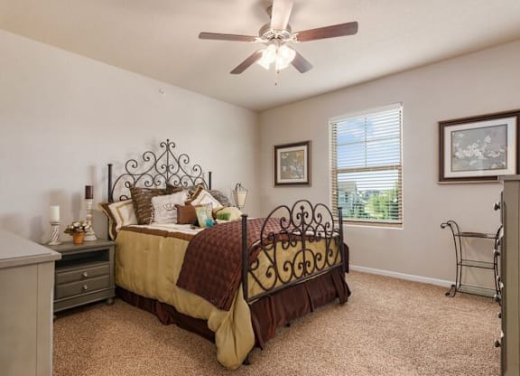 A bedroom with a bed, dresser, and window.