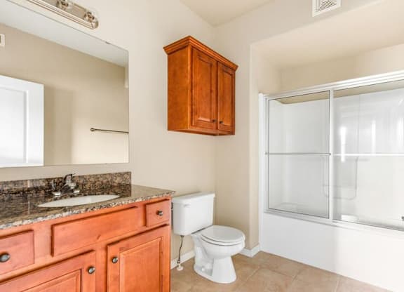 A bathroom with a toilet, sink, and shower.