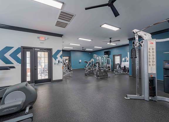 A gym with a treadmill, weights, and exercise equipment.