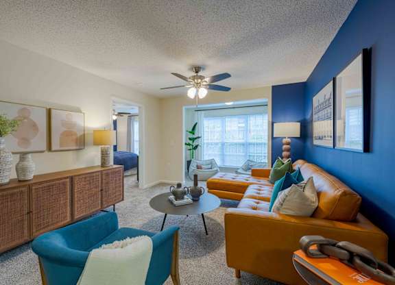 A living room with a blue chair and a yellow couch.