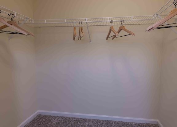 A row of clothes hangers on a rail in a room.
