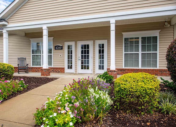 A house with a front porch and a garden in front.