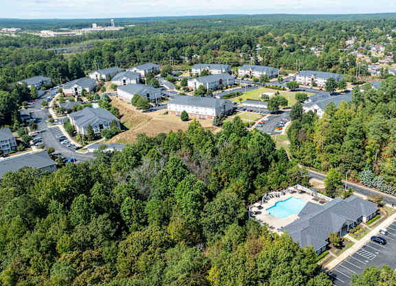 A bird's eye view of a resort with a swimming pool and a parking lot.