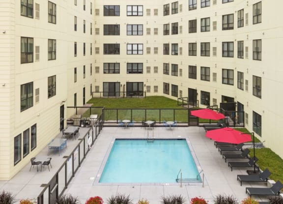 Outdoor pool and patio area with grills and fireplace C&E Living in St Paul, MN