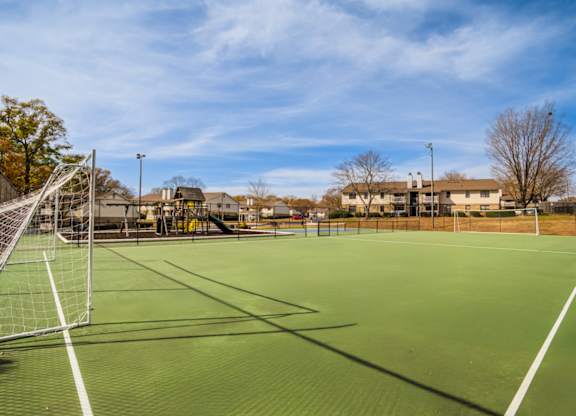 A tennis court with a net and goal post.