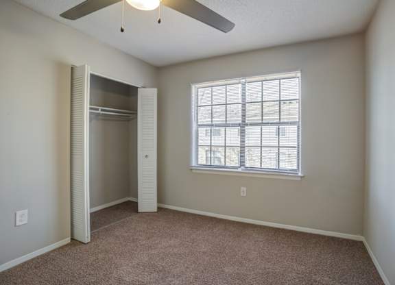 A room with a window and a ceiling fan.